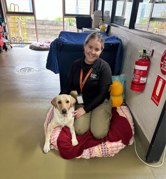 Suzannah Farrell –kneeling and smiling – At the nursery with Guide Dog mum Viv.