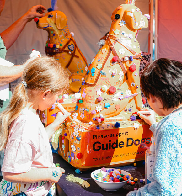 Child decorating Guide Dogs donation dog