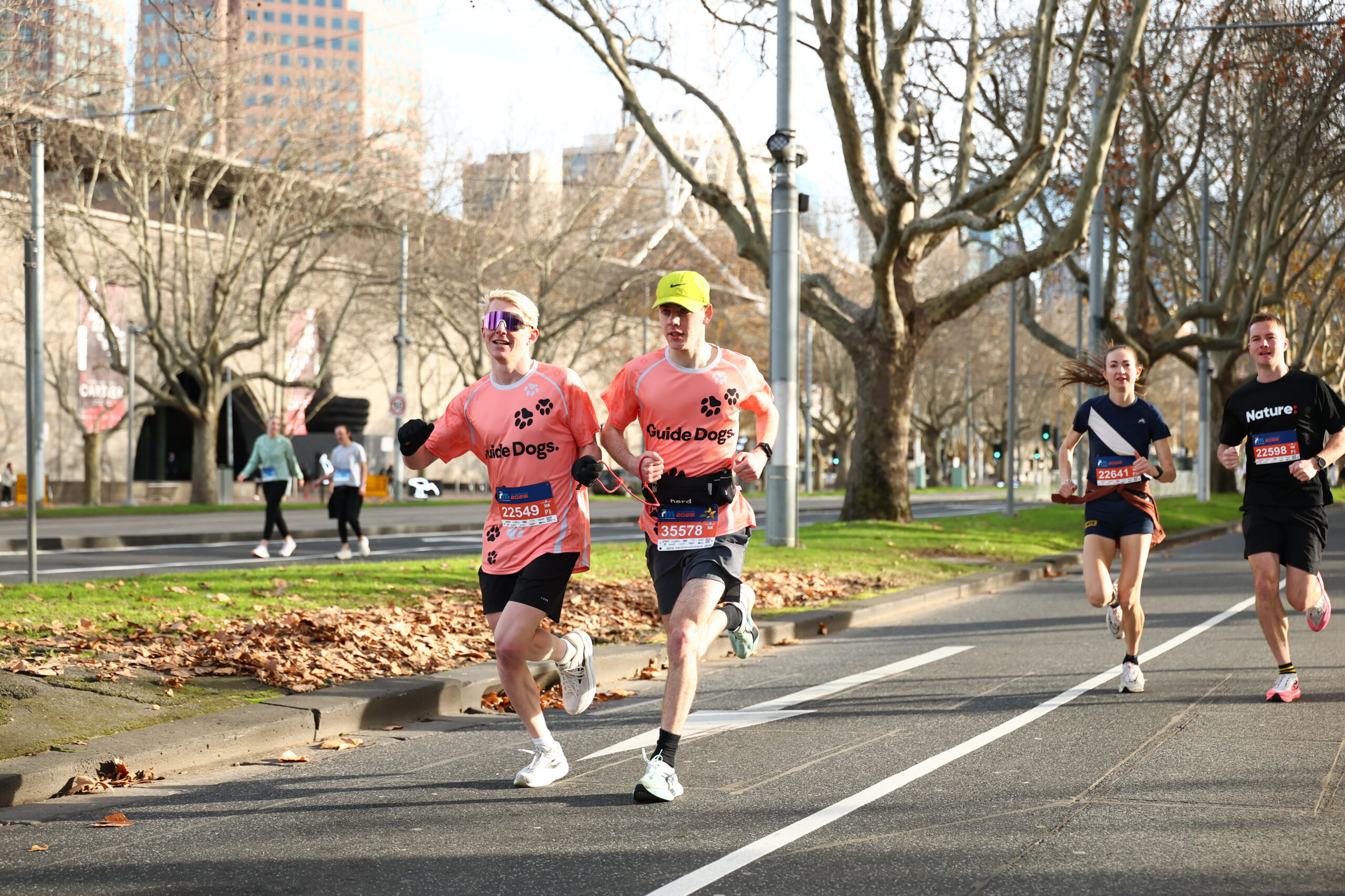 Patrick running on the left with his sighted guide, Benson running on the right