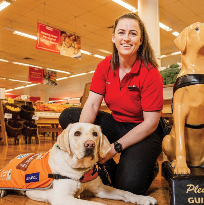 Coles Store Manager Jessica with trainee support dog Michael and an iconic Guide Dogs Donation Dog