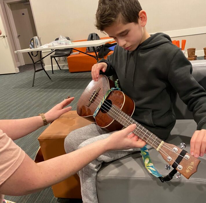 A young boy holding a guitar