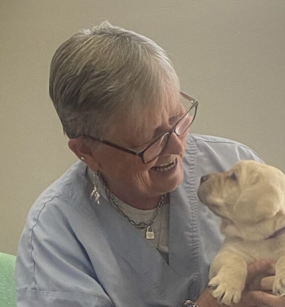 Sue holding a yellow labrador puppy