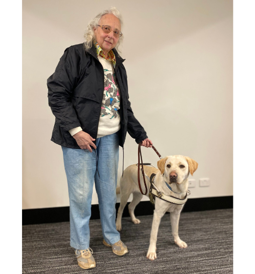 Monica standing with yellow Guide Dog