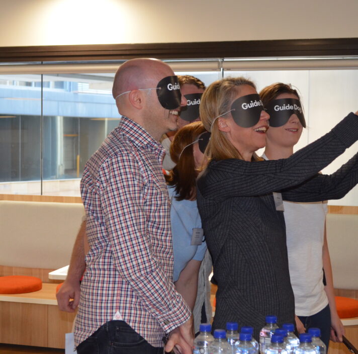 a group of people is doing vision challenge with their eyes covered