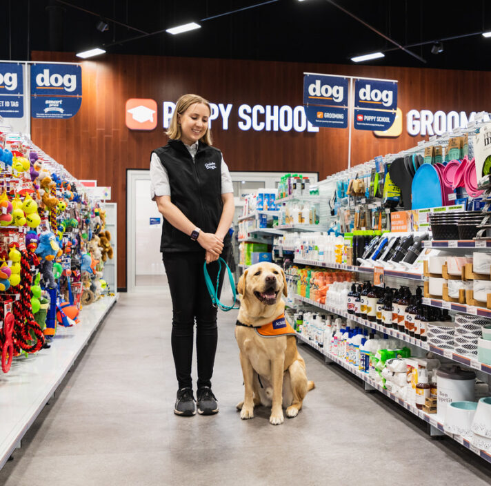 Therapy Dog Specialist Elisha with Guide Dogs Ambassador Raffa inside a Petstock store.