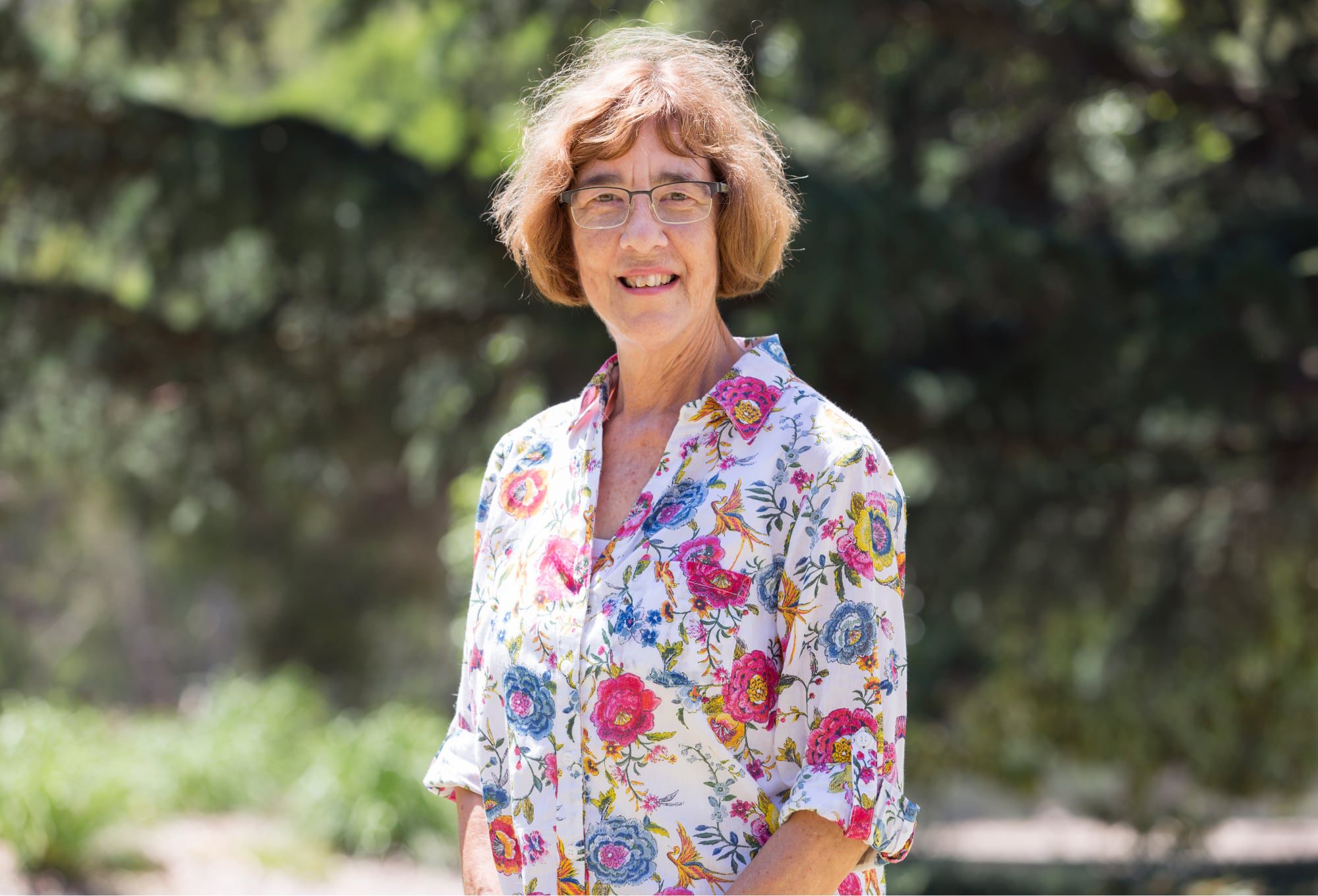 A person standing outside smiling at the camera.