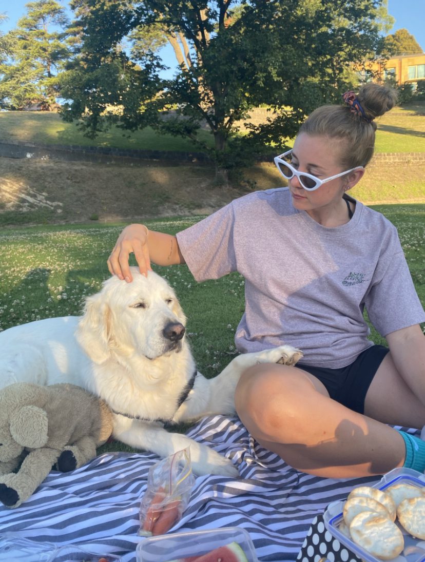 Al Viney sits on a picnic blanket and pats Charlie