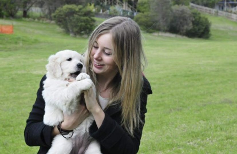 Al Viney sits outside holding puppy Charlie