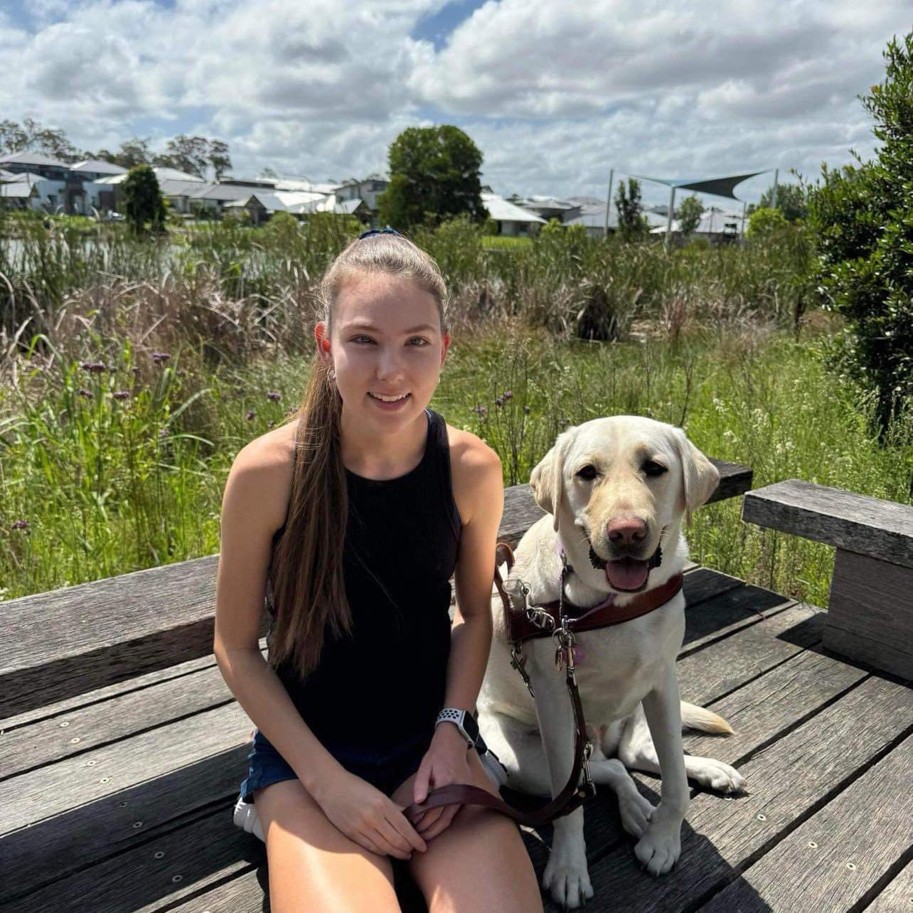 Karlee sitting next to her Guide Dog, Isla