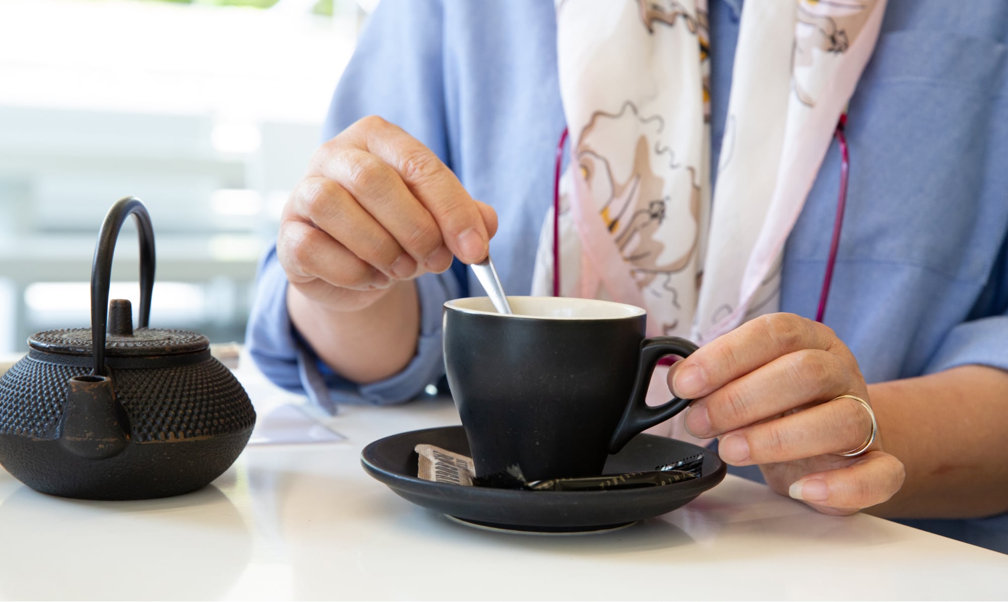 A person stirring a cup of tea.