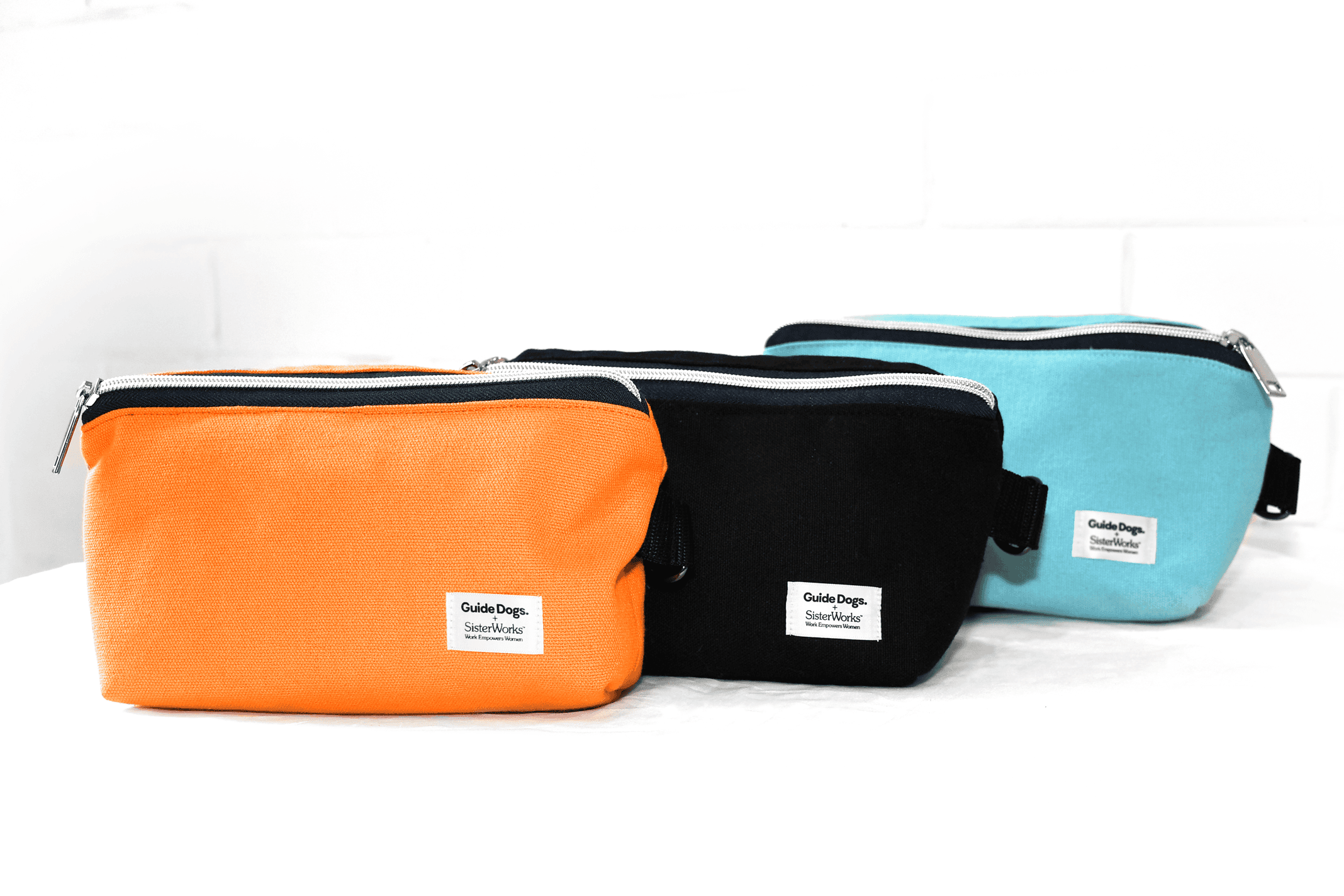 An image showing the 3 coloured treat bags. One is orange, one black and one a light blue. They all have two zip pockets and a waist strap.