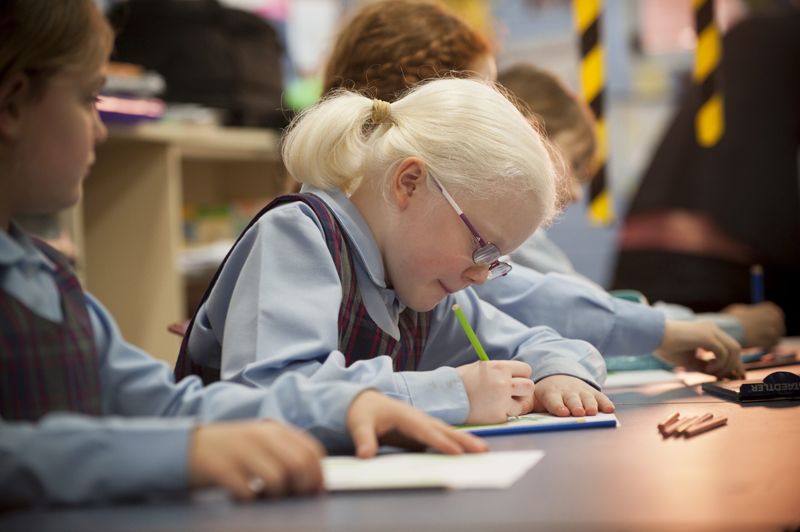 A young girl doing her schoolwork at a desk.