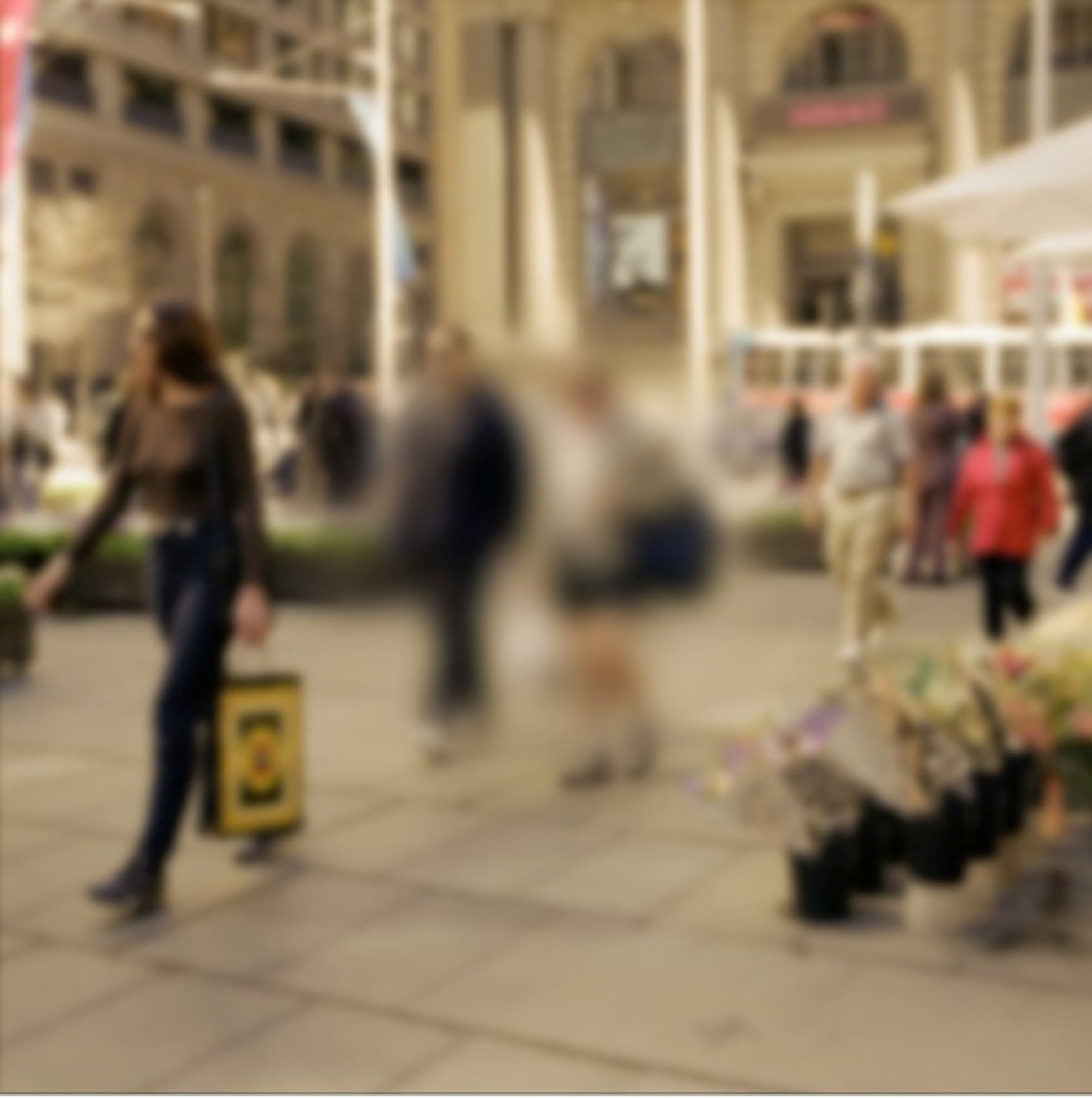 A busy shopping strip. The middle of the image is blurred to portray how someone with a cataract might view it.
