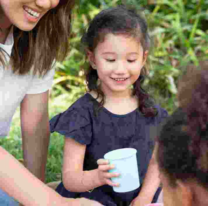 a girl is holding a cup of water