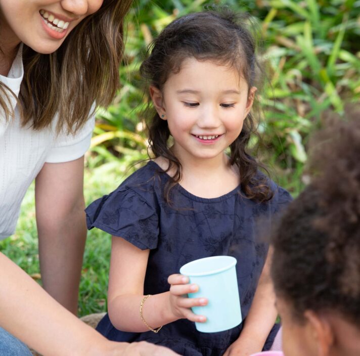 a girl is holding a cup of water