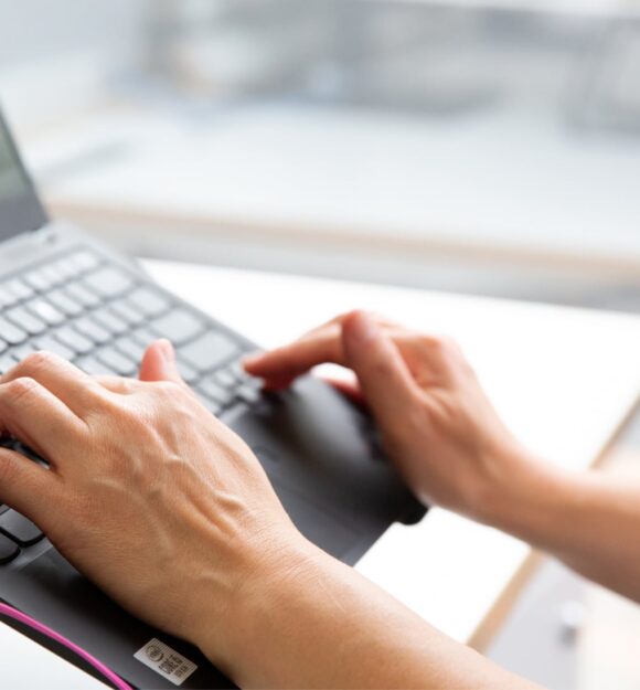 Person's hand using the keyboard of a laptop.