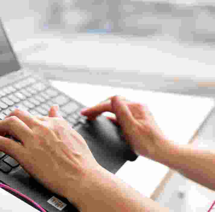 Person's hand using the keyboard of a laptop.