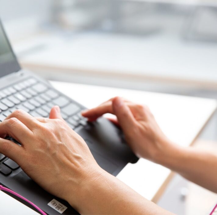 Person's hand using the keyboard of a laptop.