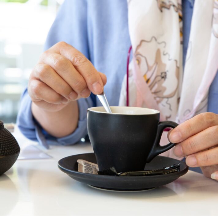 A person stirring a cup of tea.