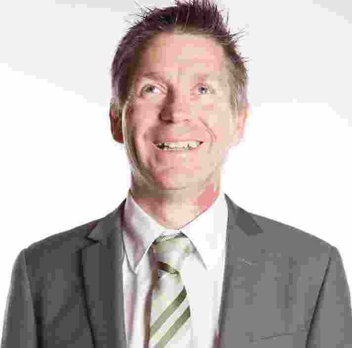 Headshot of Guide Dogs Victoria's Board Chair, Iain Edwards. Iain is looking at the camera smiling.