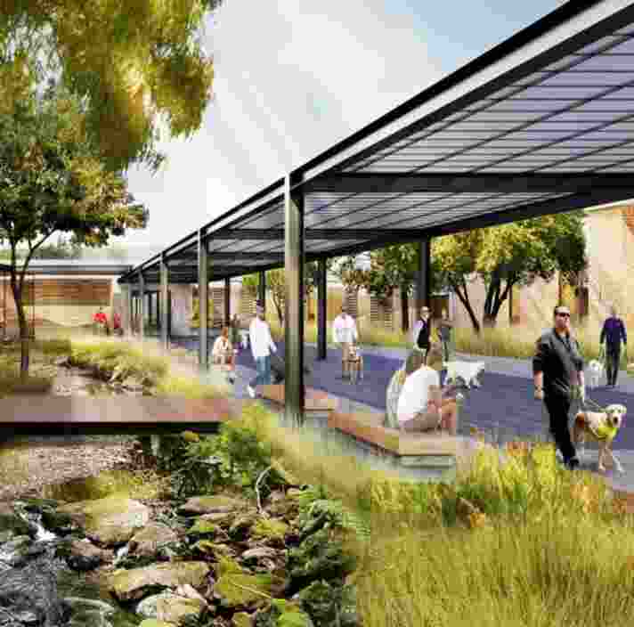 A render of a building with an outside footpath that is covered, next to a small stream with pebbles in it. Across the stream is a wooden bridge.