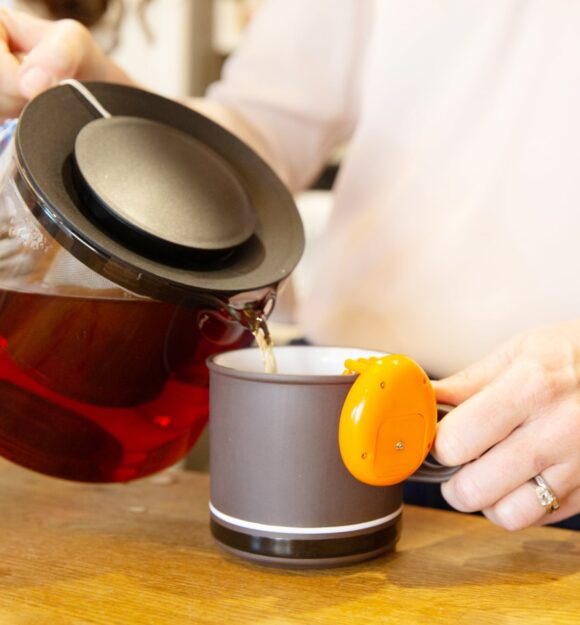 A close up shot of a person making a cup of tea.