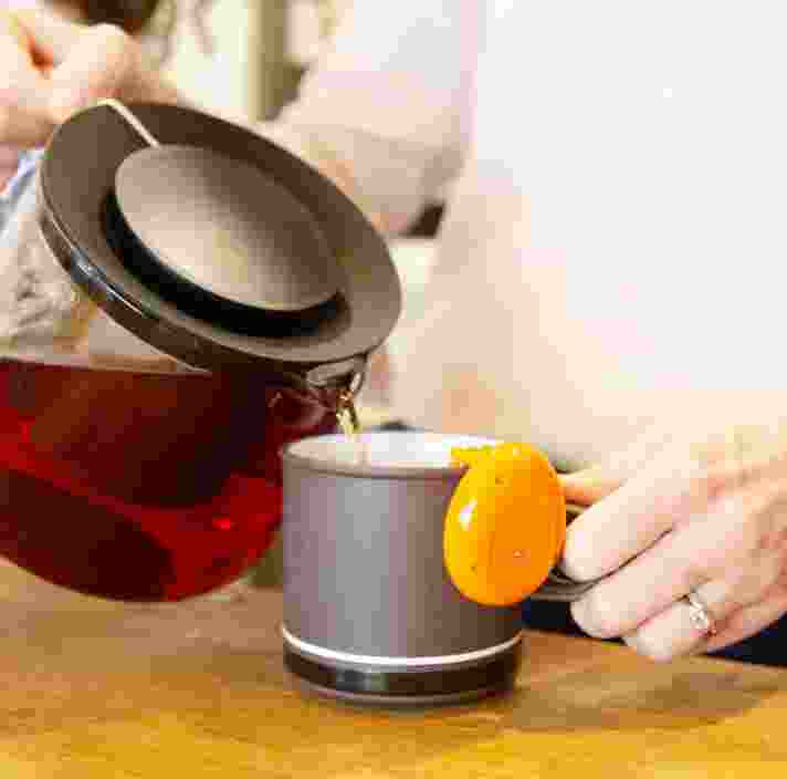 A close up shot of a person making a cup of tea.