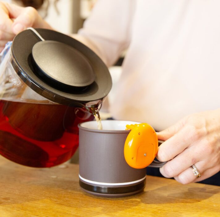 A close up shot of a person making a cup of tea.