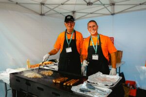 Two volunteers manning the sausage sizzle. 