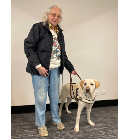 Monica standing with yellow Guide Dog