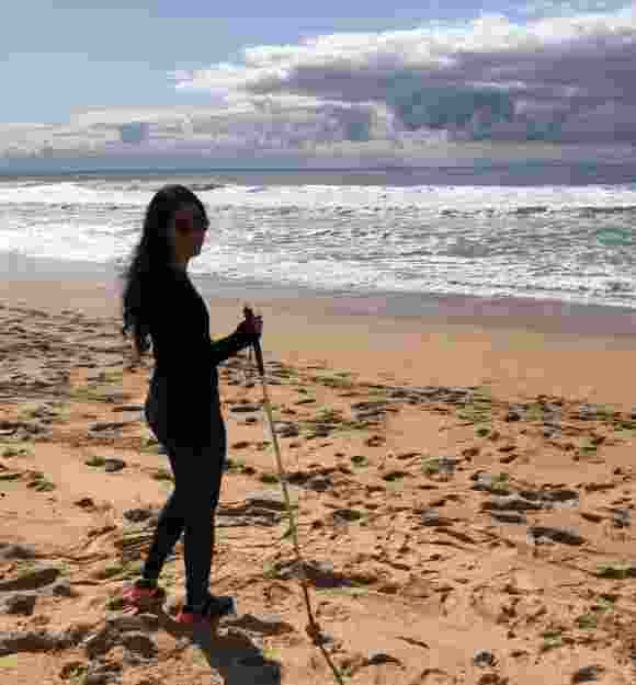 Noora on the beach with her white cane